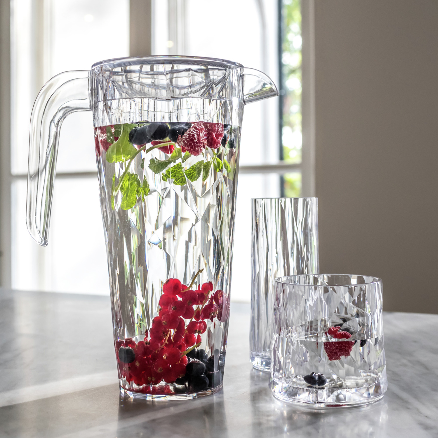 Pitcher Koziol Club Superglas 1.5L din Plastic Tehnologic Innespurtabil, Design Facetat Rezistent la Impact cu Capac Rotativ, Transparent