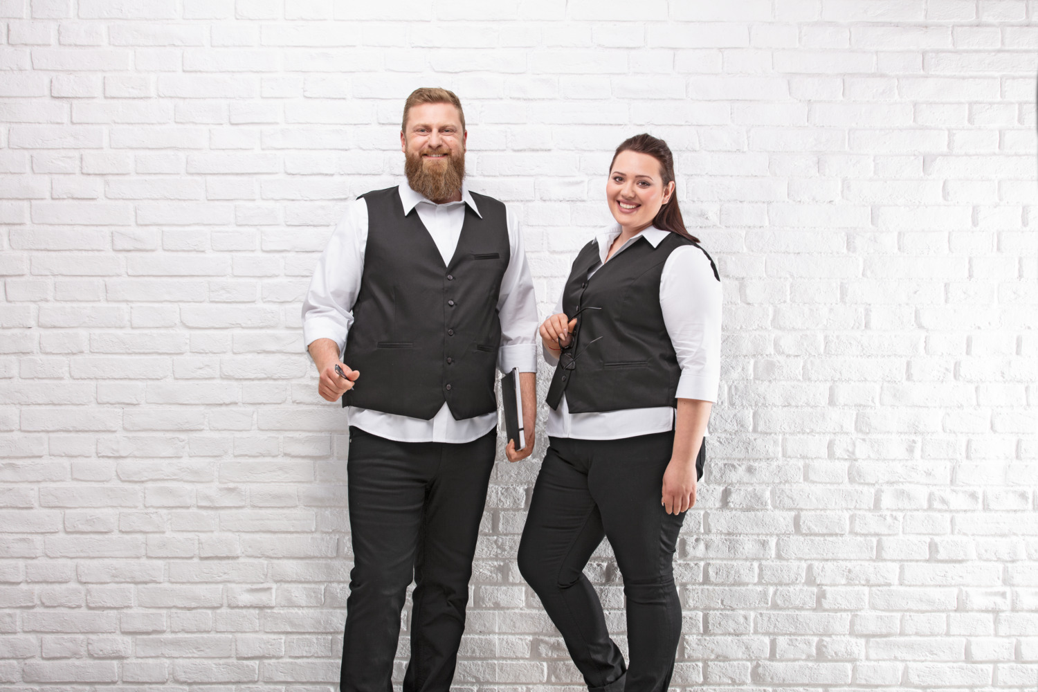 JOBELINE LUSINI Solutions GmbH Men's vest Bistro Herren Weste Bistro Men's vest Bistro; Size 46; graphite Herren Weste Bistro; Kleidergröße 46; graphit 65 % polyester, 35 % cotton. 60°C wash. Classic service waistcoat for men with adjustable back strap to adjust the width at the waist, 5-button placket, three piped outside pockets and one inside breast pocket. Comfortably cut and fully lined. Particularly hard-wearing and easy-care blended fabric. Back length: 66 cm for size 50. 65 % Polyester, 35 % Baumwolle. 60°-Wäsche. Klassische Serviceweste für den Herrn mit verstellbarem Rückenriegel zur Weitenregulierung in der Taille, mit 5-Knopfleiste, drei paspelierten Außentaschen und einer Brustinnentasche. Komfortabel geschnitten und komplett gefüttert. Besonders strapazierfähiges und pflegeleichtes Mischgewebe. Rückenlänge: 66 cm in Gr 50.