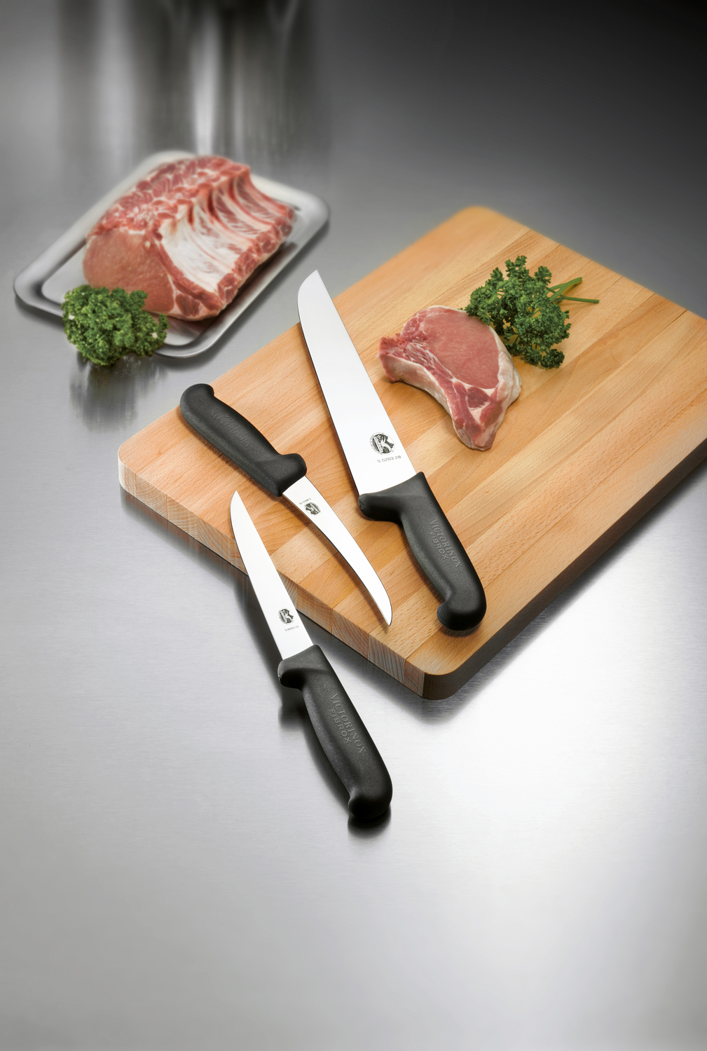 Victorinox Victorinox AG Slaughter and bench knife Fibrox straight Schlacht- und Bankmesser Fibrox gerade Slaughter and bench knife Fibrox straight; Blade length 28 cm, 41.7 cm (L); silver/black Schlacht- und Bankmesser Fibrox gerade; Klingenlänge 28 cm, 41.7 cm (L); silber/schwarz From professionals for professionals Non-slip handles guarantee safe working Particularly high edge retention for a long service life Outstanding sharpness and maximum stability The Fibrox collection was developed for professional chefs, but is also popular with amateur chefs due to its optimum performance and precise cuts. The non-slip, ergonomic handles sit comfortably in the hand and are easy on the wrist. This makes cooking and cutting fun! Extra-sharp stainless steel blades glide through even the thickest cuts of meat and sophisticated special knives handle a variety of kitchen tasks - from filleting fish to glazing cakes. Material handle: Thermoplastic elastomers (TPE) combine the easy processing of thermoplastics with the advantages of elastomers. They are extremely flexible even at high temperatures, very robust and have high impact and notch resistance even at low temperatures. TPE materials can withstand temperatures of up to 110°C. Von Profis für Profis Rutschfeste Griffe garantieren sicheres Arbeiten Besonders hohe Schnitthaltigkeit für eine lange Lebensdauer Hervorragende Schärfe und maximale Stabilität Die Fibrox Kollektion wurde für Profiköche entwickelt, ist aber auch bei Hobbyköchen aufgrund ihrer optimalen Performance und präzisen Schnitte beliebt. Die rutschfesten, ergonomischen Griffe liegen gut in der Hand und schonen das Handgelenk. So machen Kochen und Schneiden Spaß! Extra scharfe Klingen aus rostfreiem Stahl gleiten selbst durch die dicksten Fleischstücke und ausgereifte Spezialmesser erledigen verschiedene Küchenaufgaben – vom Filetieren von Fisch bis zum Glasieren von Torten. Material Griff: Thermoplastische Elastomere (TPE) kombinieren die einfache Verarbeitung von Thermokunststoffen mit den Vorteilen von Elastomeren. Sie sind auch bei hohen Temperaturen extrem flexibel, sehr robust und besitzen sogar bei niedrigen Temperaturen eine hohe Schlag- und Kerbschlagfestigkeit. TPE-Materialien halten Temperaturen von bis zu 110 °C stand.