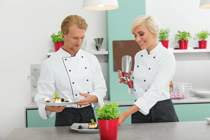 PULSIVA LUSINI Solutions GmbH Women's chef jacket Aila cotton half sleeve colored piping Damenkochjacke Aila Baumwolle Halbarm farbige Paspel Women's chef jacket Aila cotton half sleeve colored piping; Size 56; white/black Damenkochjacke Aila Baumwolle Halbarm farbige Paspel; Kleidergröße 56; weiß/schwarz 100 % cotton. 200 g/m². 60 °C wash. Modern, durable women's chef jacket made of easy-care cotton in half sleeves. With double row 6-button closure, double button placket and removable ball buttons. There is a contrasting colored piping at the collar and closure edge. This classic chef jacket features a patch chest pocket. Also available in long sleeve. Straight cut with maximum freedom of movement. Delivery incl. black ball buttons. Back length: 73 cm for size 36. 100 % Baumwolle. 200 g/m². 60°-Wäsche. Moderne, strapazierfähige Damenkochjacke aus pflegeleichter Baumwolle in Halbarm. Mit zweireihigem 6-Knopf Verschluss, doppelter Knopfleiste und abnehmbaren Kugelknöpfen. Am Kragen und an der Verschlusskante befindet sich ein farbiger Kontrastpaspel. Die klassische Kochjacke verfügt über eine aufgesetzte Brusttasche. Auch in Langarm erhältlich. Gerader Schnitt mit höchster Bewegungsfreiheit. Lieferung: inkl.schwarzer Kugelknöpfe. Rückenlänge: 73 cm in Gr 36