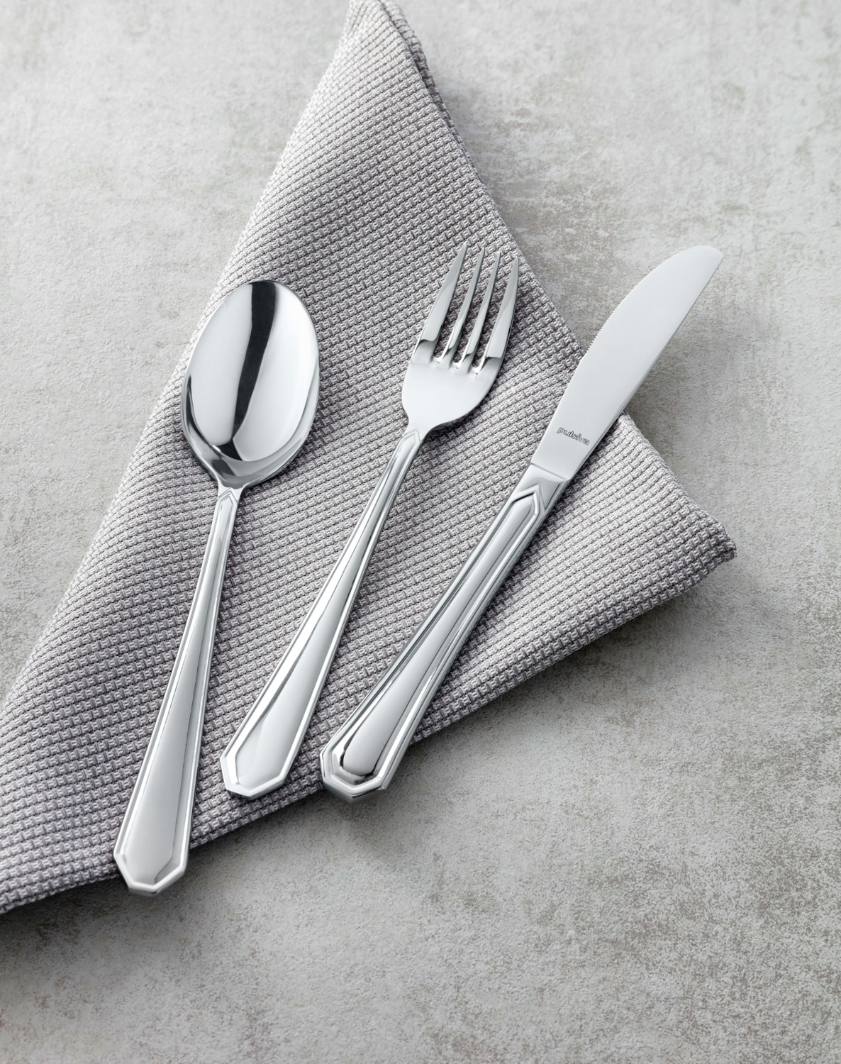 PULSIVA LUSINI Solutions GmbH Table spoon Tunis Basic Menülöffel Tunis Basic Table spoon Tunis Basic; 19.5 cm (L); silver, handle silver; 12 piece / pack Menülöffel Tunis Basic; 19.5 cm (L); silber, Griff silber; 12 Stück / Pack 18/0 chrome-stainless steel, rustproof. Classic table spoon. Mirror polished. Material thickness 2.2 mm (measured at the thickest point of the table fork). Suitable for dishwasher. Chrom-Edelstahl 18/0, rostfrei. Der Menülöffel Tunis Basic bietet eine hochglanzpolierte Oberfläche und eine solide 2,2 mm (gemessen an der stärksten Stelle der Menügabel) starke Verarbeitung. Durch seine ausgewogene Form liegt er angenehm in der Hand und eignet sich ideal für Restaurants, Kantinen und Catering. Das 18/0 Material ist spülmaschinengeeignet und für den Dauergebrauch optimiert. Ihre Vorteile auf einen Blick: • Spülmaschinengeeignet – hygienisch & leicht zu reinigen • Magnetisch – optimal für Polier- und Sortiersysteme • Nickelfrei – ideal auch für empfindliche Gäste