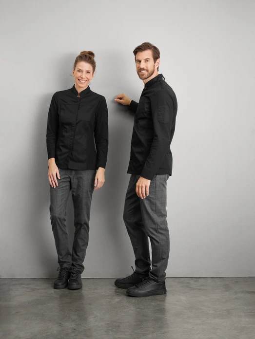 JOBELINE LUSINI Solutions GmbH Women's chef's jacket Phoenix long-sleeved Damen Kochjacke Phoenix Langarm Women's chef's jacket Phoenix long-sleeved; Size 46; black Damen Kochjacke Phoenix Langarm; Kleidergröße 46; schwarz 65 % polyester, 35 % cotton. 150 g/m². 60 °C wash. Elegant women's chef jacket made of extra lightweight, breathable fabric. With a small wing collar, inner breast pocket, concealed button tape and a 2-part upper arm pocket. With a practical bib apron loop in the neck. The side panels and entire sleeves are made of an elastic piqué material, which is extremely breathable and ensures a very comfortable fit. The sleeves feature fully elastic, classic shirt cuffs with button and sleeve vent. Slightly tailored cut. Back length: 68 cm for size 36. 65 % Polyester, 35 % Baumwolle. 150 g/m². 60°-Wäsche Elegante Damenkochjacke aus einem extraleichten und atmungsaktiven Gewebe. Mit kleinem Stehkragen, innenliegender Brusttasche, verdeckter Druckknopfleiste, sowie einer zweigeteilten Oberarmtasche. Mit einer praktischen Latzschürzenschlaufe im Nacken. Die Seitenteile sowie die gesamten Ärmel bestehen aus einem atmungsaktiven und elastischen Piqué Material, das für eine äußerst bequeme Passform und Atmungsaktivität sorgt. Den Ärmelabschluss bildet eine ebenfalls vollelastische, klassische Hemdenmanschette mit Druckknopf und Ärmelschlitz. Leicht tailliert geschnitten. Rückenlänge: 68 cm in Gr. 36